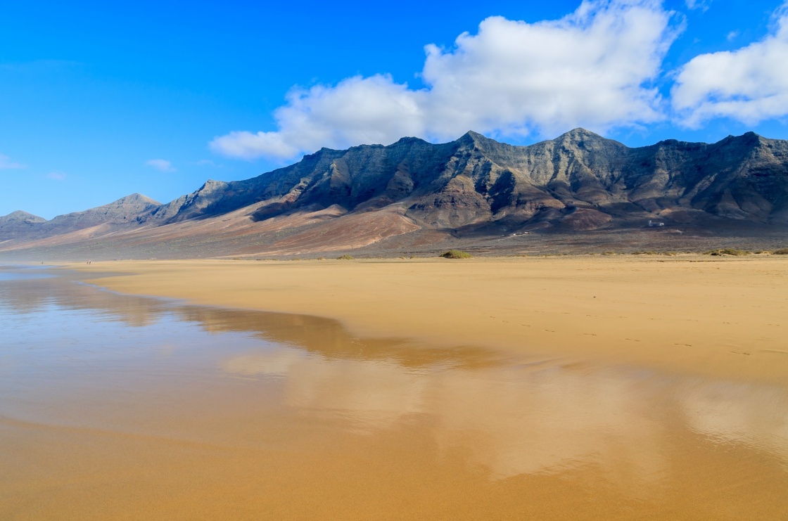 'Reflection of mountains in wet sand on Cofete beach in secluded part of Fuerteventura, Canary Islands, Spain' - Isole Canarie